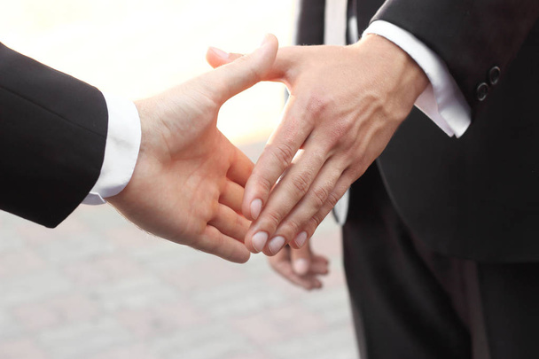 close up.two businessman holding out hand for handshake - Fotó, kép