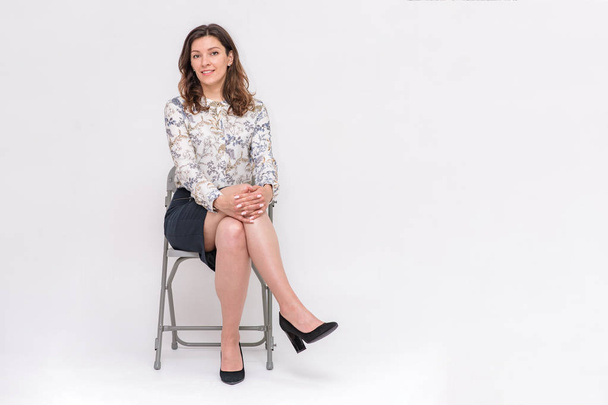 girl sitting on a chair on a white background in different poses - Foto, Imagem