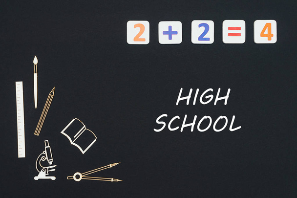 Schulmaterial auf schwarzem Hintergrund mit Text High School platziert - Foto, Bild