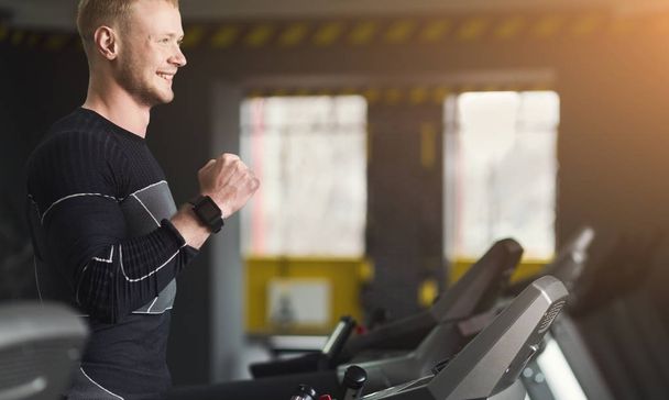 Young man in gym running on treadmill - Foto, imagen