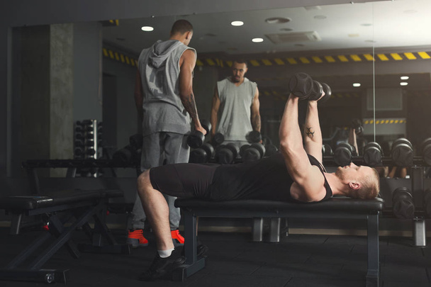 Dos hombres haciendo ejercicio con mancuerna en el gimnasio
 - Foto, imagen