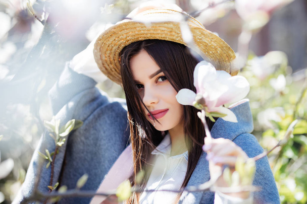 Bir çiçek açması bahar Manolya bahçede genç güzel bir beyaz kız. - Fotoğraf, Görsel