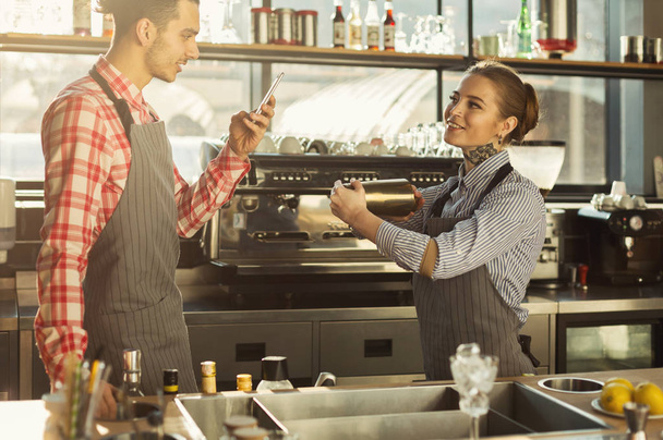 Male and female bartenders at coffee shop counter - Foto, Imagem