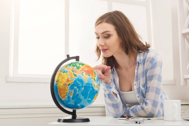 Mulher sonhando com viagens, olhando para o globo
 - Foto, Imagem
