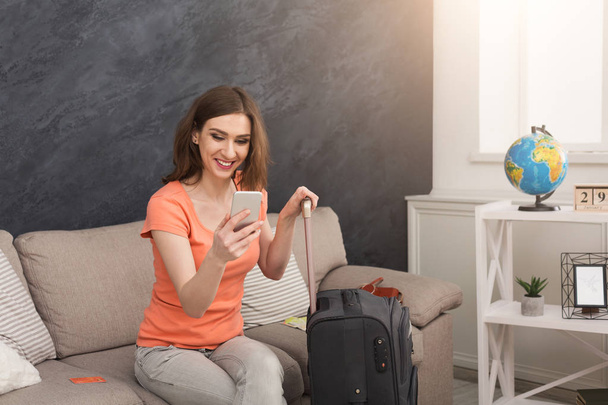Woman ready for travel, sitting with suitcase - Фото, зображення