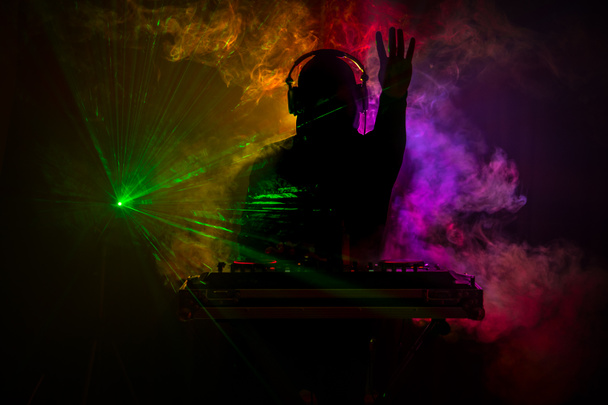 DJ Spinning, Mixing, and Scratching in a Night Club, Manos de dj ajustar varios controles de pista en la cubierta de dj, luces estroboscópicas y niebla, o Dj mezcla la pista en el club nocturno en la fiesta. Enfoque selectivo
 - Foto, Imagen