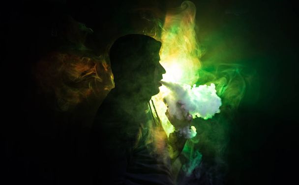 Vaping ember, aki egy mod. Egy felhő-ból gőz. ködös sötét tónusú, háttérben a füst. Vaping elektronikus cigaretta füst egy csomó. VAPE koncepció. Szelektív összpontosít - Fotó, kép