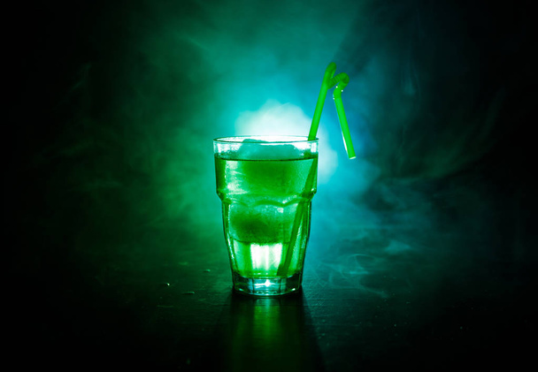 Алкогольный коктейль в стакане со льдом в дыму на темном тонированном фоне. Концепция напитков. Один бокал коктейля
 - Фото, изображение