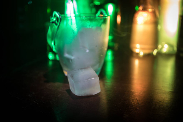 Szkła wiadro lodu na tle butelek alkoholu niewyraźne światła i dymu. Napoje klubu. Club bar biurko. Gotowy do służby. Selektywny fokus - Zdjęcie, obraz