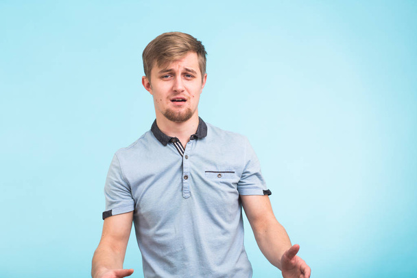 Shocked or surprised young man on blue background - Photo, Image