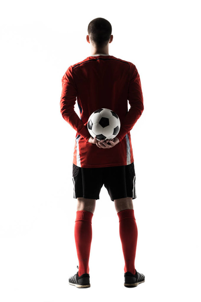 Achteraanzicht van silhouet van de jonge voetballer geïsoleerd op witte achtergrond - Foto, afbeelding