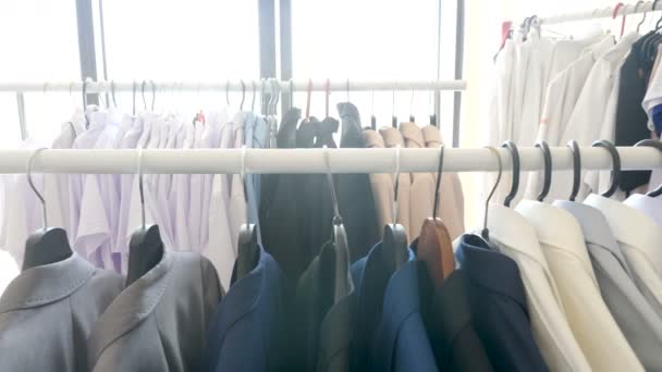Kleiderbügel mit verschiedenen Kleidungsstücken, Business und Casuals in einem Geschäft - Filmmaterial, Video
