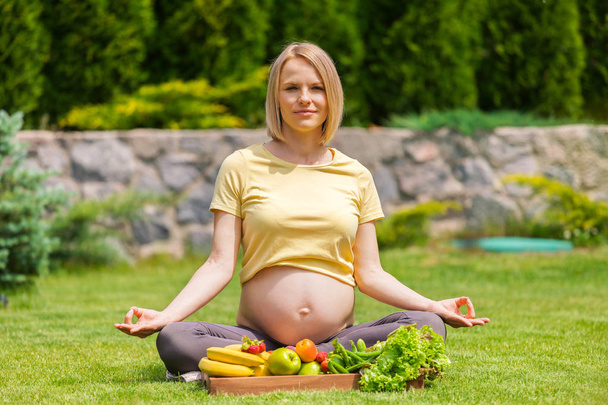Pregnant woman practicing meditation and relaxation in nature - Zdjęcie, obraz