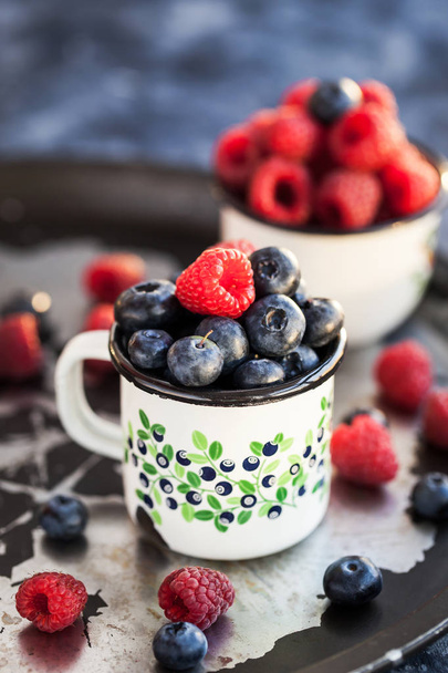Fresh ripe blueberry and raspberry in mugs  - Zdjęcie, obraz