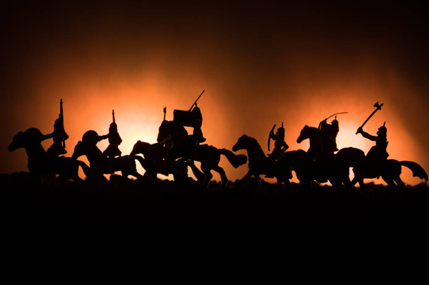 Középkori harci jelenet, a lovasság és a gyalogság. Sziluettek számok külön objektumokként küzdelem között a sötét tónusú ködös háttér harcosok. Éjszakai élet. - Fotó, kép