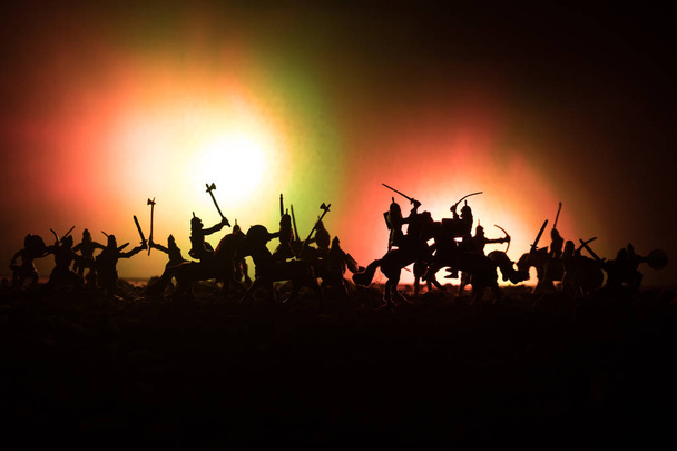 Middeleeuwse slag scène met de cavalerie en infanterie. Silhouetten van figuren als afzonderlijke objecten, strijd tussen krijgers op donker getinte mistige achtergrond. Nachtbeeld. - Foto, afbeelding