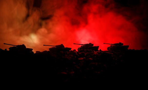Концепция войны. Военные силуэты боевой сцены на фоне тумана войны, силуэты немецких танков мировой войны под облачным горизонтом ночью. Сцена нападения. Бронетехника. Танковая битва. Закрыть
 - Фото, изображение