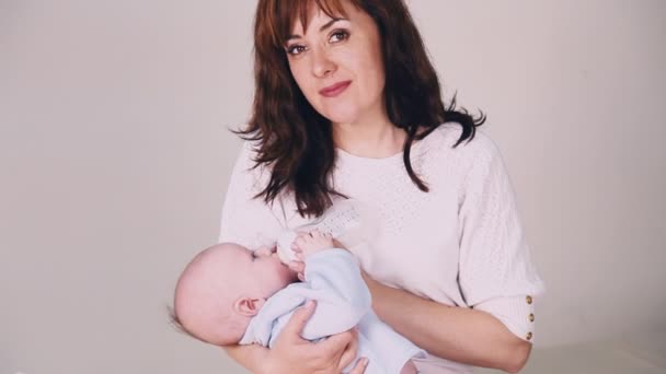 moeder is het voeden van de baby melk uit een fles - Video