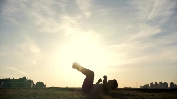 Lassú mozgású - fiatal férfi Parkour tricker jumper végez csodálatos fejtetőre előtt a nap - Felvétel, videó
