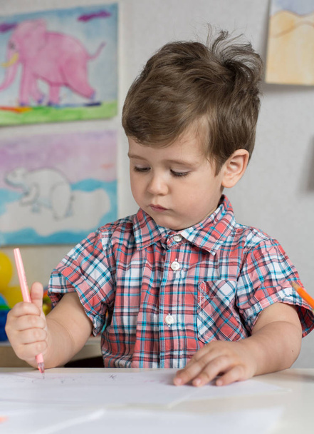 Preschool kid playing and writing at kindergarten or playschool. Creative toddler, school concept. - Photo, image