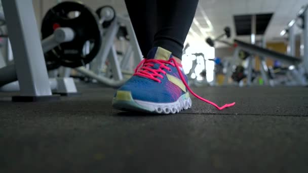 Laufschuhe - Frau bindet Schnürsenkel im Fitnessstudio - Filmmaterial, Video