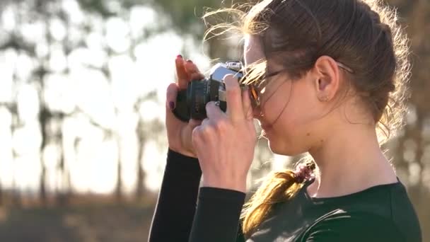 Beautiful girl takes pictures of her beloved man on a film camera. Slow motion - Footage, Video