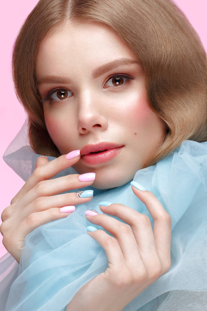 Beautiful girl with light make-up and gentle manicure in blue clothes. Beauty face. Design nails. - Foto, Bild