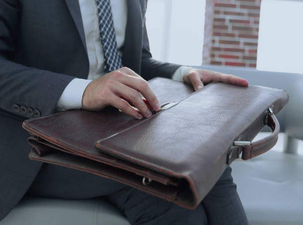 businessmans hand with suitecase in a modern office - Foto, Bild