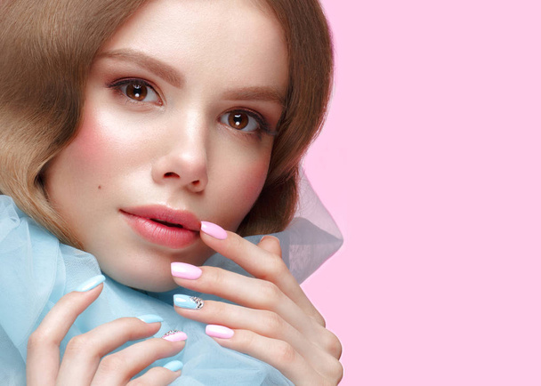 Beautiful girl with light make-up and gentle manicure in blue clothes. Beauty face. Design nails. - Фото, зображення