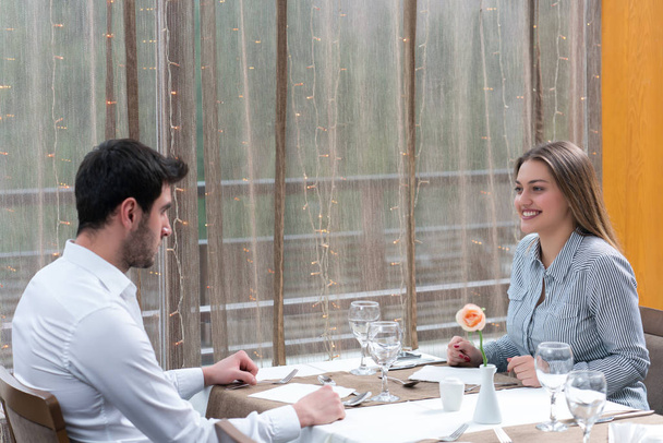 φαγητό, Χριστούγεννα, αργίες και οι άνθρωποι έννοια - χαμογελώντας ζευγάρι τρώει κυρίως πιάτο στο εστιατόριο - Φωτογραφία, εικόνα