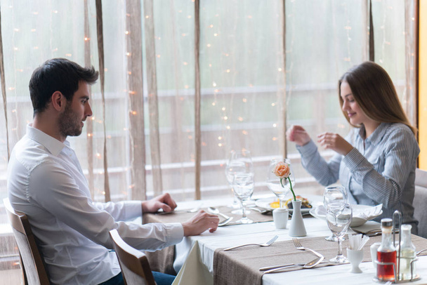 comida, Navidad, vacaciones y concepto de personas - pareja sonriente comiendo plato principal en el restaurante
 - Foto, imagen