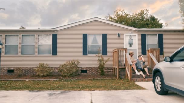 Чоловік і жінка сидять на сходинках свого дому п'ятьох один одного
 - Кадри, відео