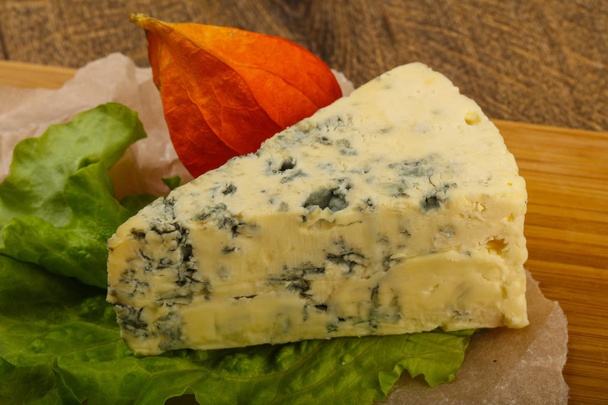 Modrý sýr se salátovými listy na dřevěném pozadí - Fotografie, Obrázek