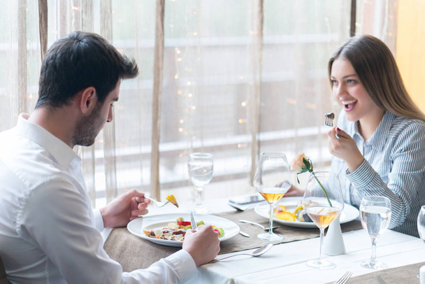 food, christmas, holidays and people concept - smiling couple eating main course at restaurant - Foto, imagen