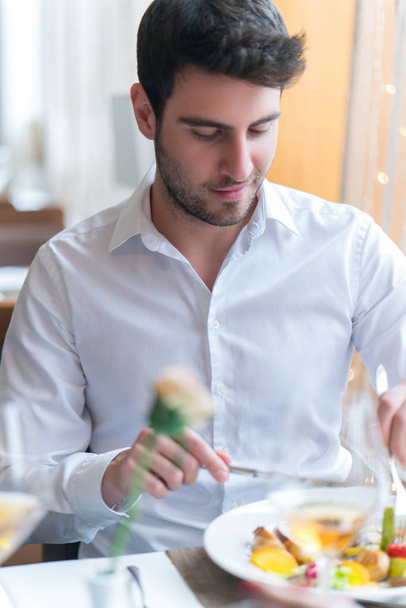Young man eating a healthy food at restaurant - Фото, изображение