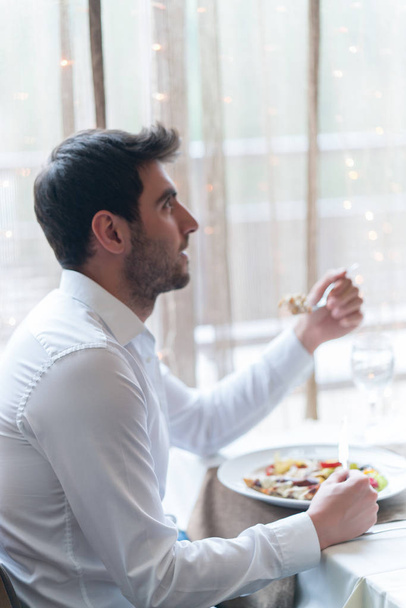 Young man eating a healthy food at restaurant - Photo, Image