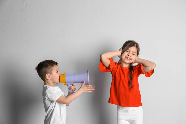 Adorable little kids with megaphone on light background - Photo, image