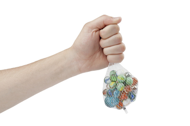 mano humana sosteniendo bolsa de red de canicas
 - Foto, imagen