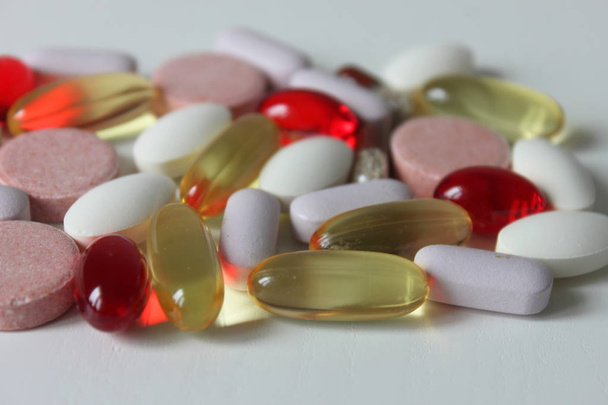 Varias medicinas coloridas y píldoras de diferente tamaño y forma. Pastillas y cápsulas sobre fondo blanco
 - Foto, Imagen