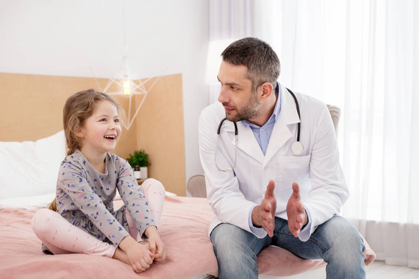 Kind doctor visiting a little girl - 写真・画像
