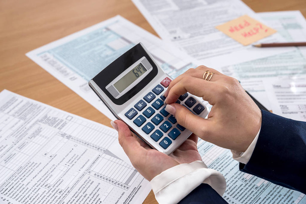 Женщина заполняет налоговую форму US 1040 в 2018 году
 - Фото, изображение