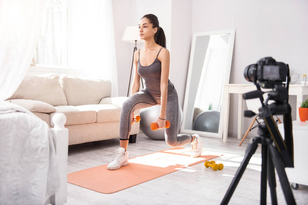 Athletic woman exercising and recording herself on camera - Foto, Imagem