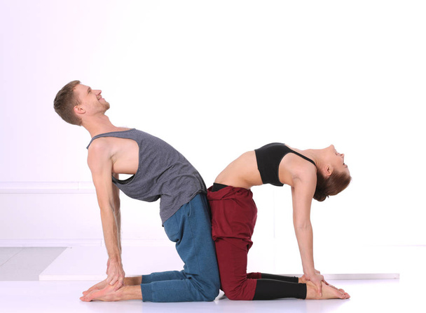 Young athletic couple practicing acroyoga. Balancing in pair. - Valokuva, kuva