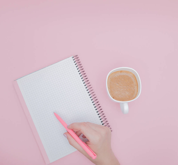 Women hand with writing on note book blank on the pink background, instagram and business concept - Фото, изображение