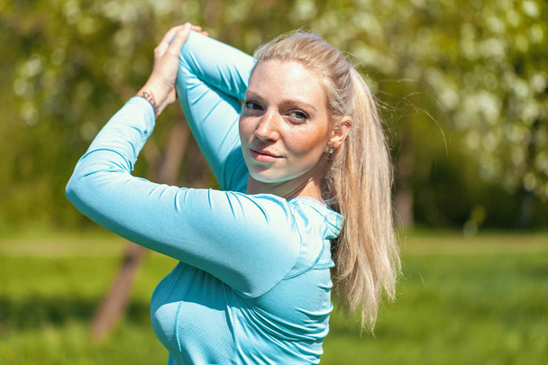 Young woman is stretching in a sport dress - Photo, Image