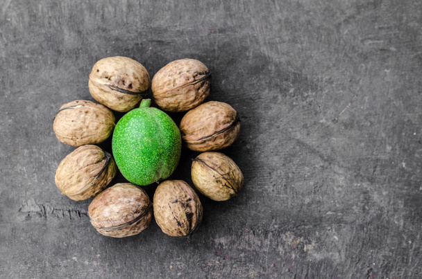 Текстурированные очищенные грецкие орехи вокруг одного зеленого
 - Фото, изображение