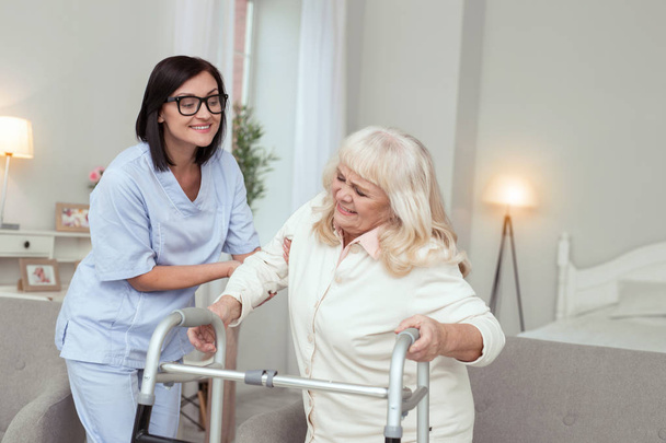 Professional nurse giving assistance to elder woman - Fotó, kép