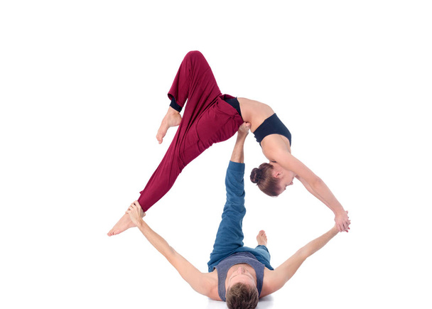 Young athletic couple practicing acroyoga. Balancing in pair. - Photo, image