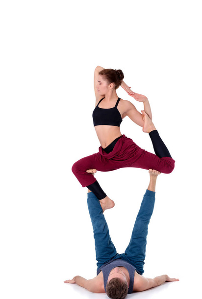 Young athletic couple practicing acroyoga. Balancing in pair. - Foto, immagini