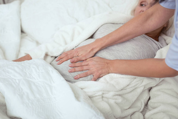 Female caregiver defining pain area - Foto, immagini